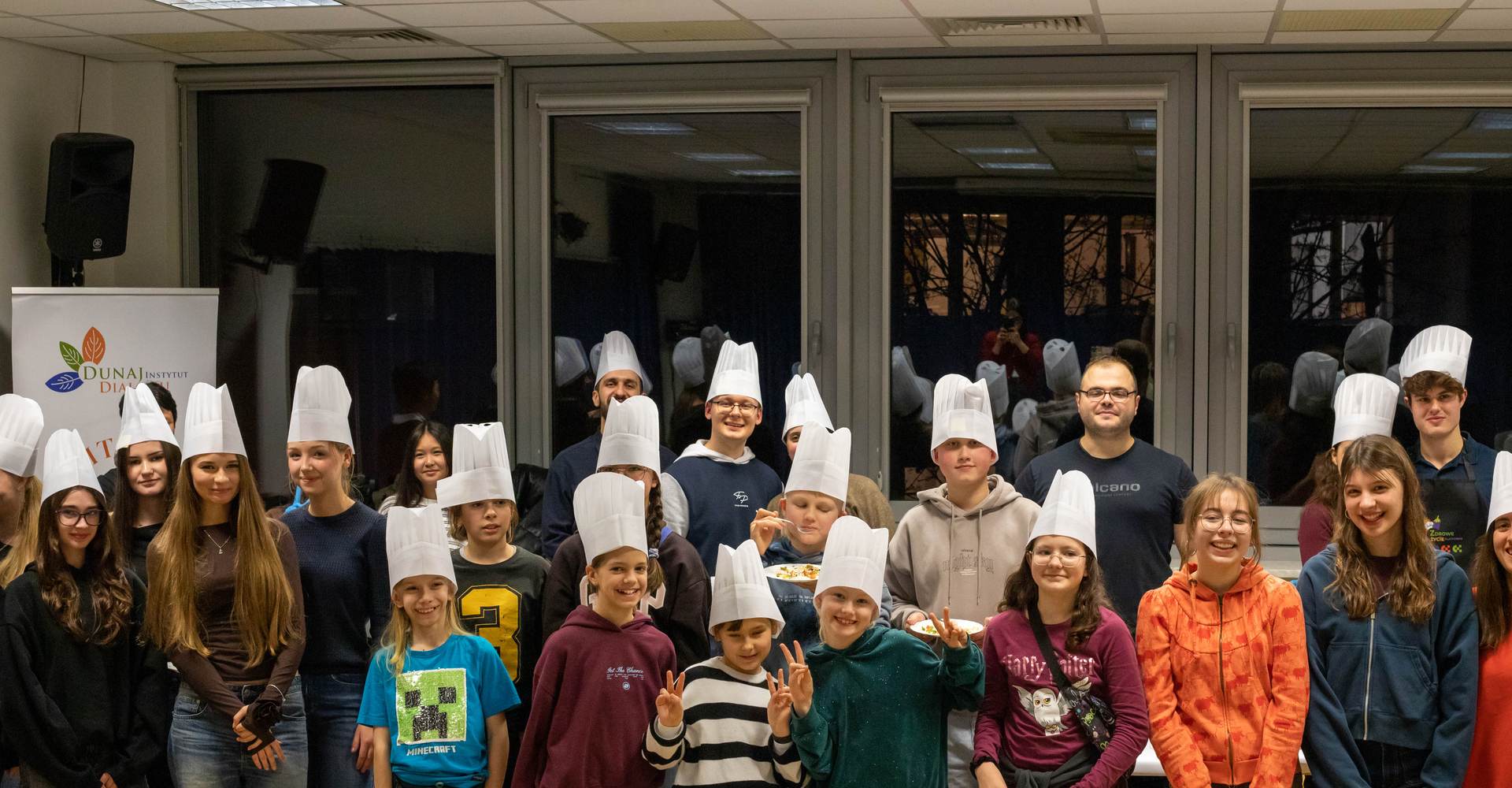Młodzież w czapkach kucharskich podczas warsztatów kulinarnych fundacji